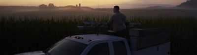 Hombre parado en su camión al atardecer